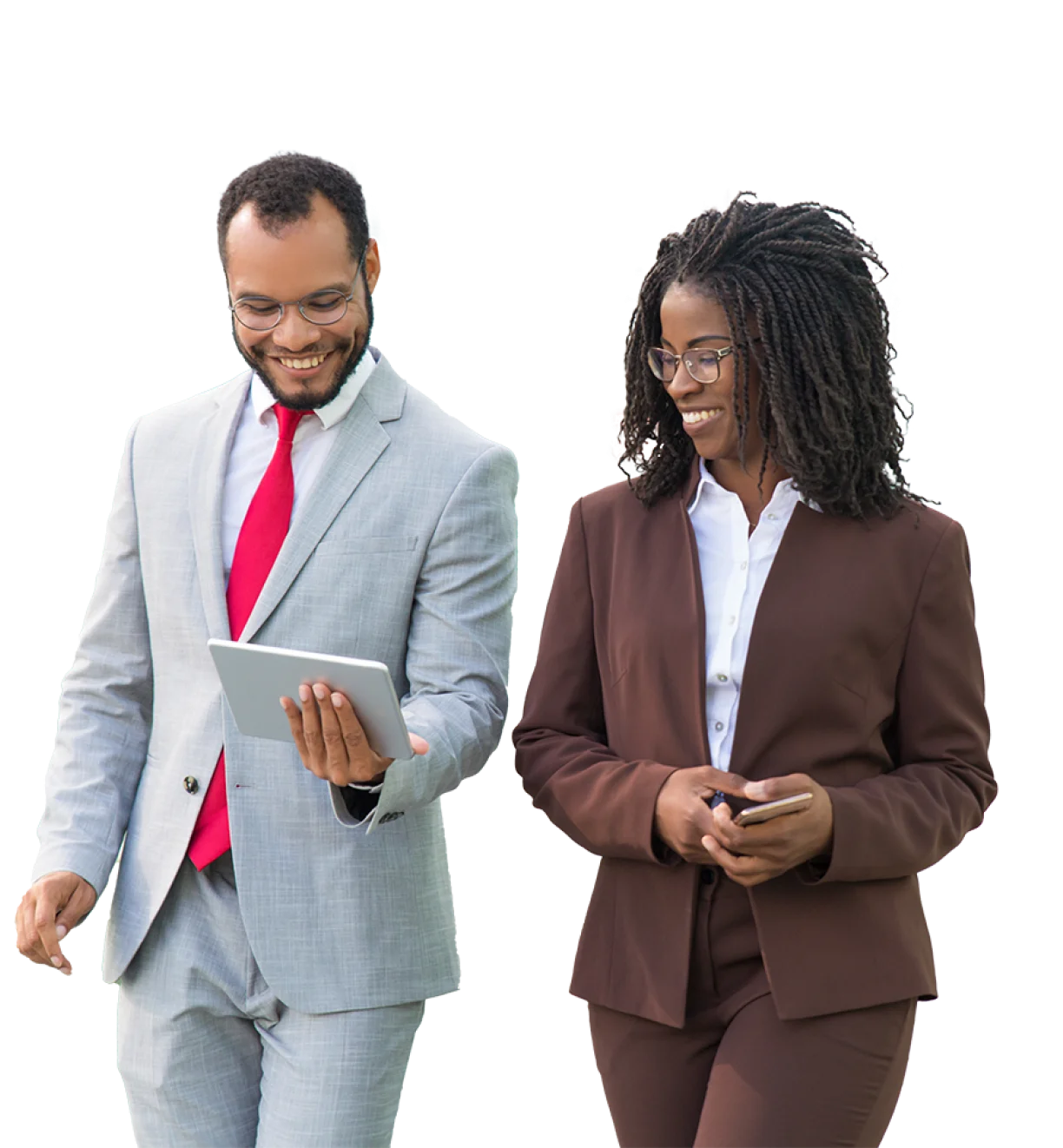 man in suit and woman in brown suit walking and smiling while looking at ipad